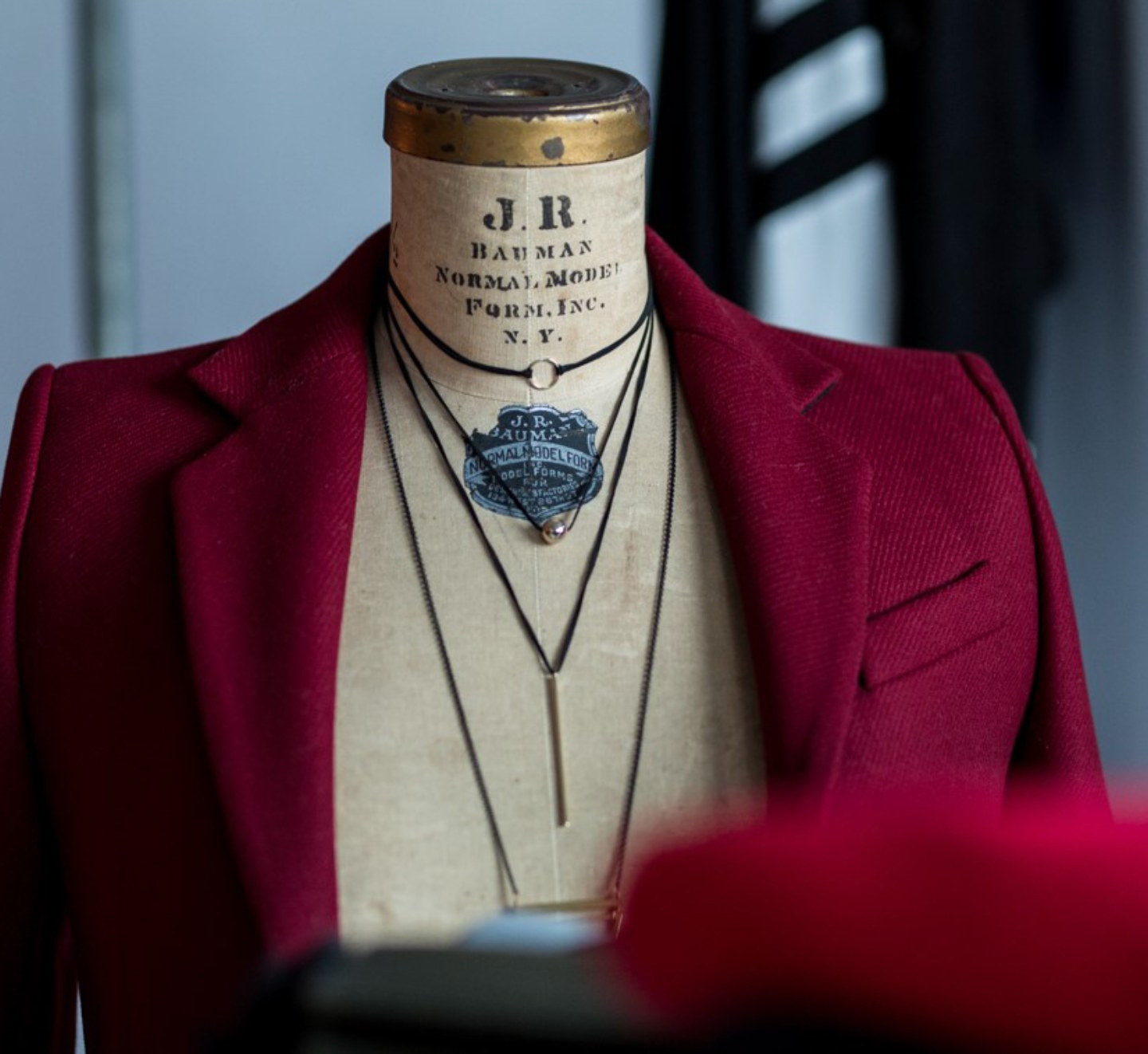 Mannequin de couturière portant un veston bordeaux